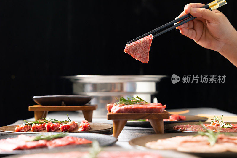 女子用筷子用手捏起和牛。烤日本优质和牛西冷牛排