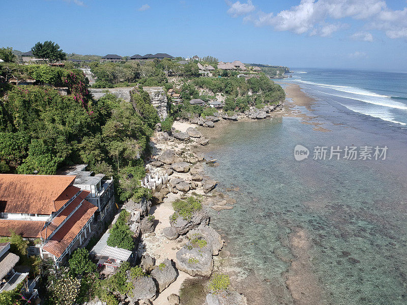 2023年8月，一个阳光明媚的日子，在退潮期间，无人机在巴厘岛乌鲁瓦图的宾金海滩拍摄的照片，周围有餐馆、房子和人们