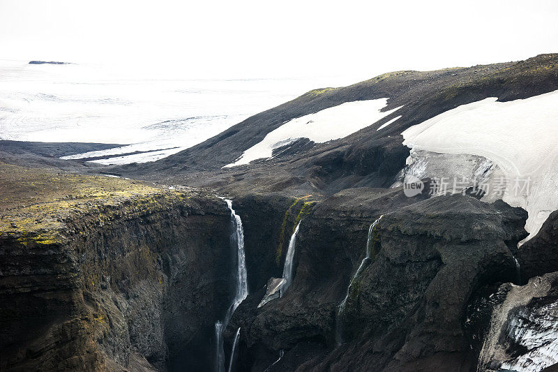 水从冰岛Eyjafjallajökull这个荒凉的火山锥的一侧倾泻而下