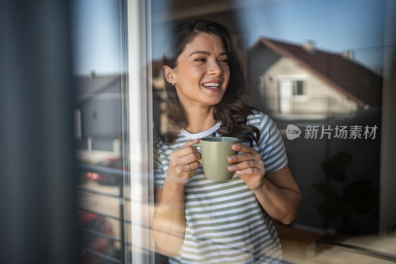 平静的春天早晨——一位年轻女子在她的公寓里享受着早晨的咖啡