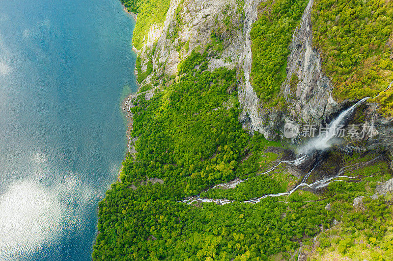 鸟瞰风景秀丽的瀑布落入水晶蓝色的海在挪威