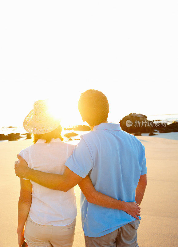 一对中年夫妇在海滩上欣赏日落