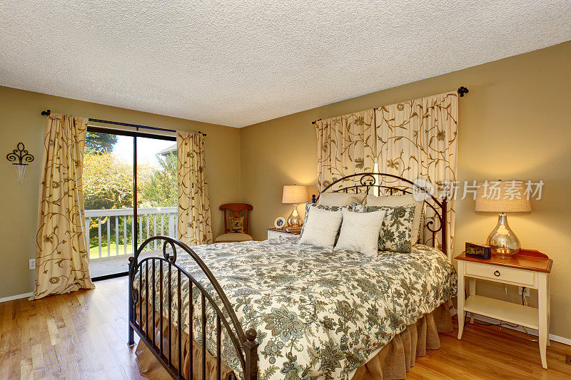 永恒的卧室与花卉床上用品和硬木地板。