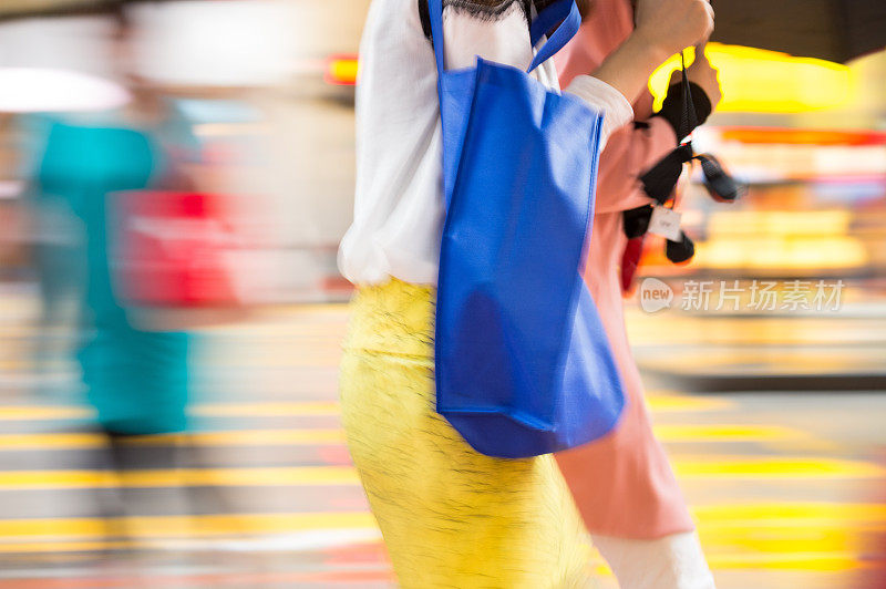 动作模糊的女人拿着包在香港街道上