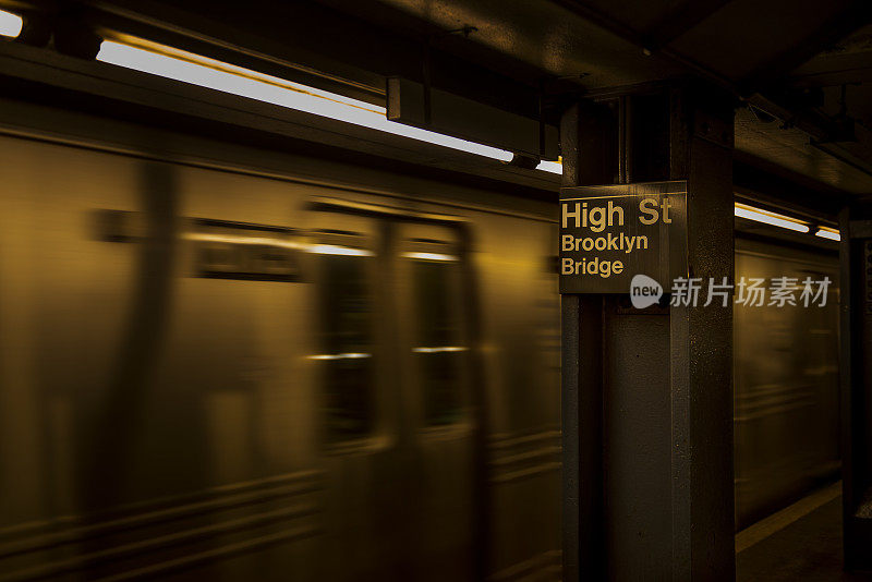 移动的地铁列车与高圣布鲁克林桥地铁标志在布鲁克林，纽约