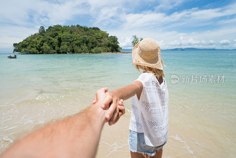 跟随我的概念-年轻女子带领男子到热带海滩