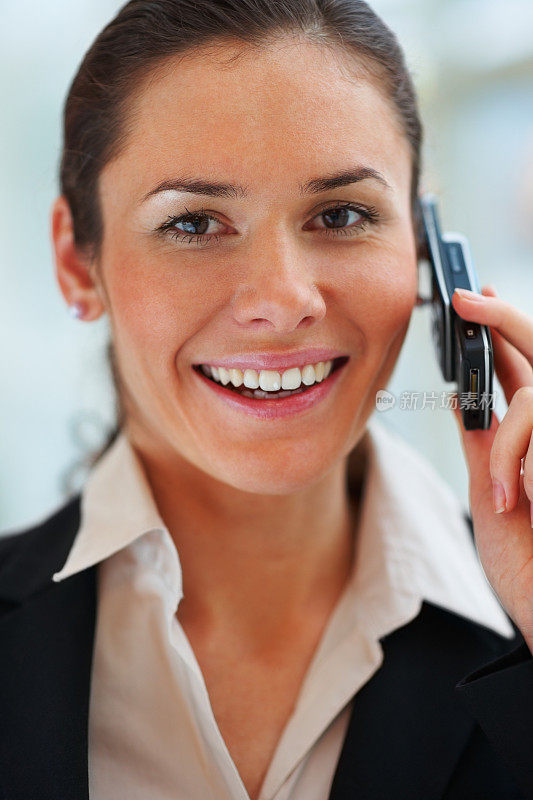 年轻快乐的商业女人微笑和交流的手机特写