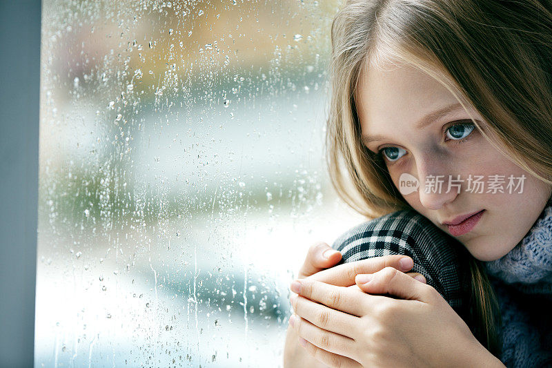 雨天:悲伤的窗户上的女孩