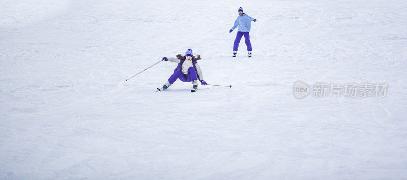 两个女孩在滑雪胜地的兔子斜坡上