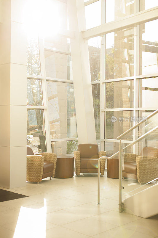 建筑风格:现代办公大堂。玻璃，钢制楼梯，窗户。椅子。