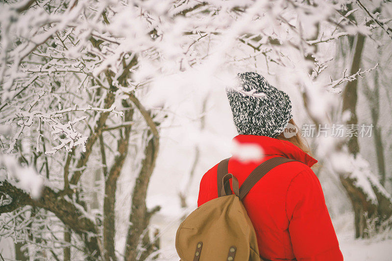 冬季运动活动。女徒步旅行者背包和雪鞋在雪地上的雪鞋