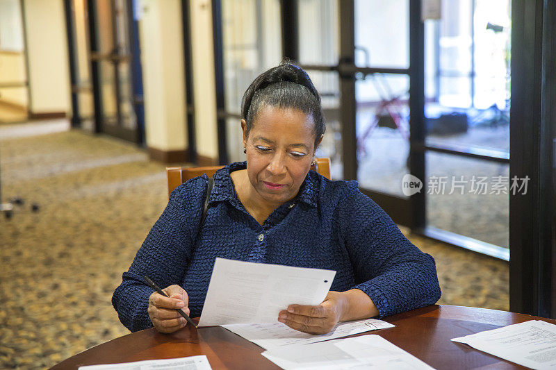 非裔美国妇女坐在桌子旁填写工作申请表