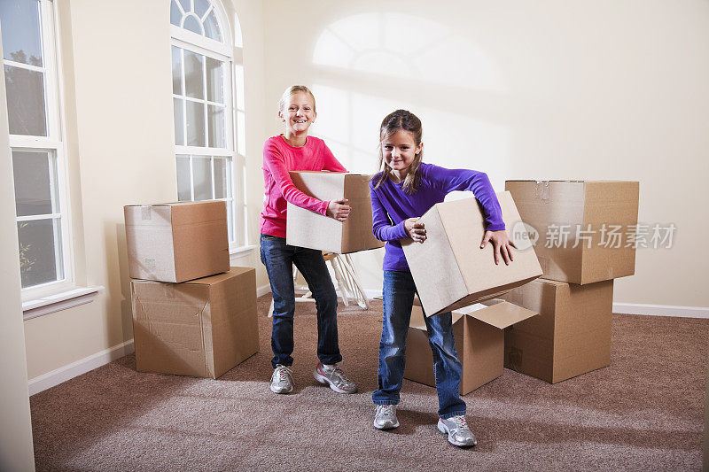 两个小女孩在帮着搬箱子