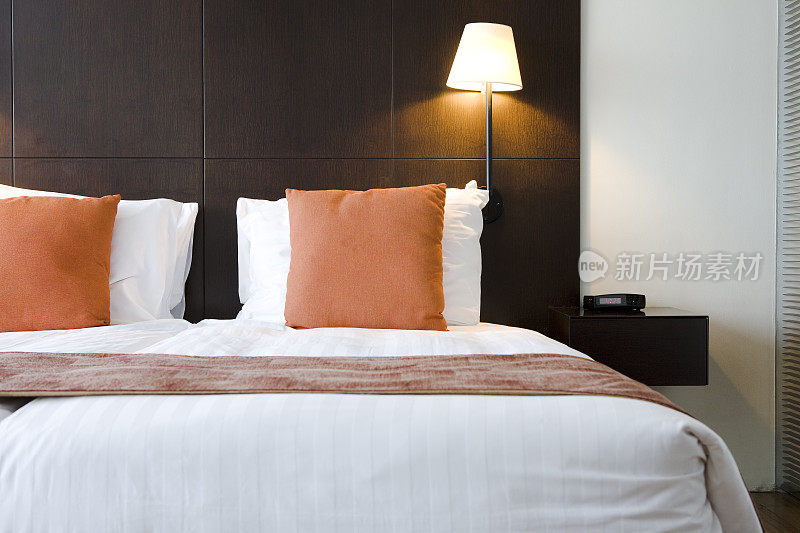 酒店房间里的床，橙色枕头