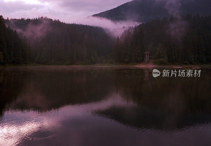日落时山上的湖上有雾。