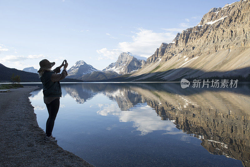 女人用智能手机拍湖，山