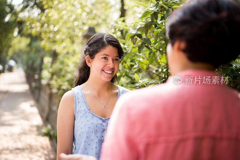 拉丁女孩和母亲面对面站着