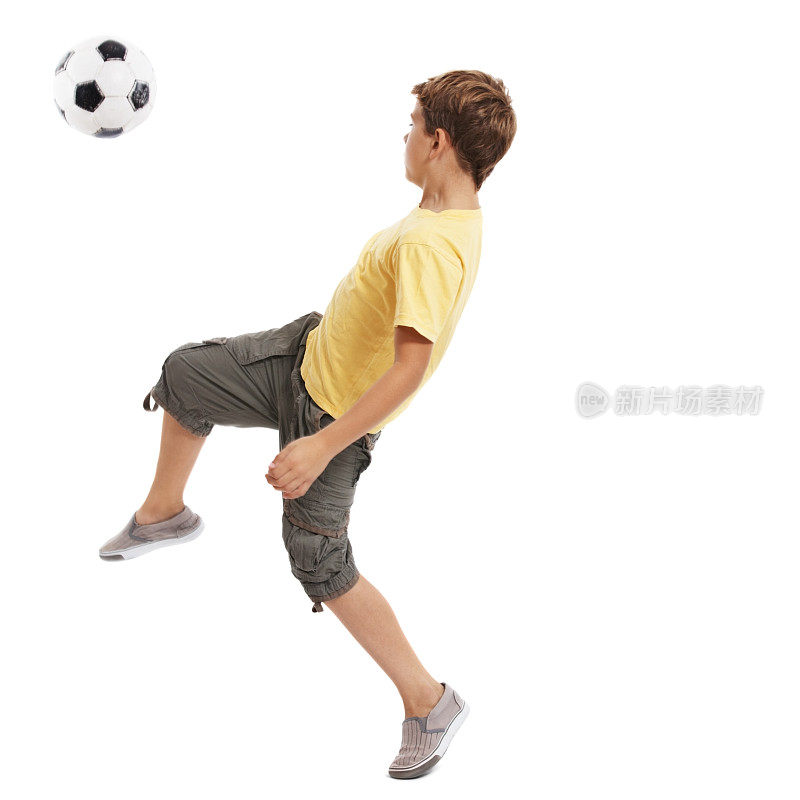 运动的小孩在白色的背景下踢足球