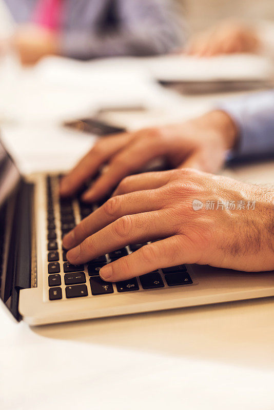 近距离观察一个不认识的商务人士在电脑键盘上打字。
