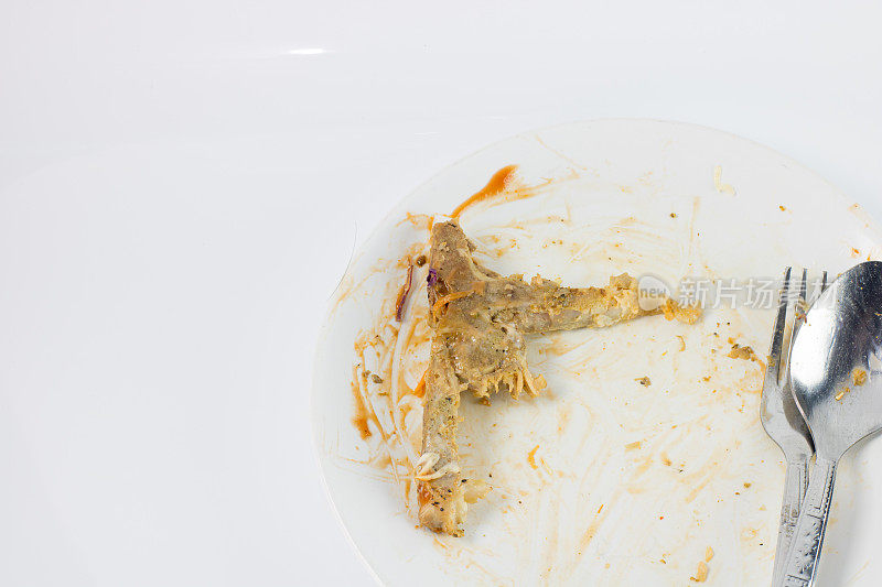 吃完后关骨牛排放在白色的盘子上，用废食隔离背景，废食隔离鸡骨，复制空间，用甜酱