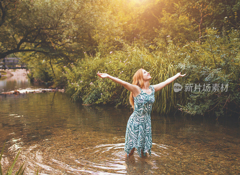 幸福的女人举起双臂享受生活