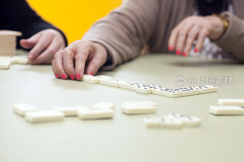 退休老妇人玩多米诺骨牌