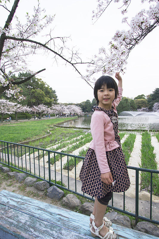 春天，小女孩站在公园里