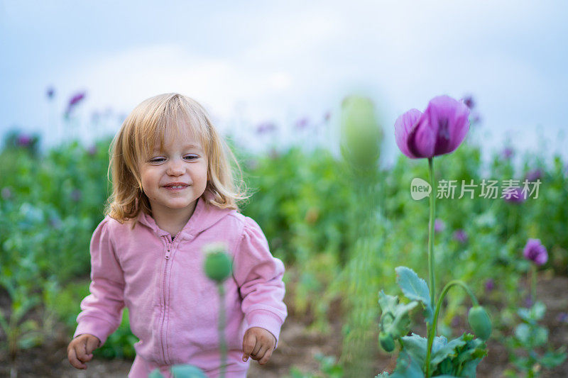 小女孩在乡村风景中嗅花