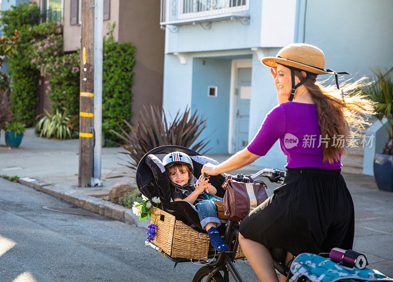 微笑的蹒跚学步的孩子骑在货运自行车