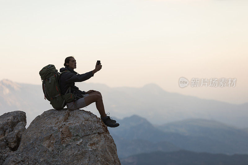 登山者在山顶使用智能手机