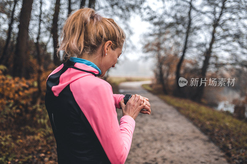 年轻的女运动员在智能手表上检查脉搏