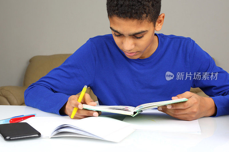 穿着蓝色夹克的黑人少年在读一本书