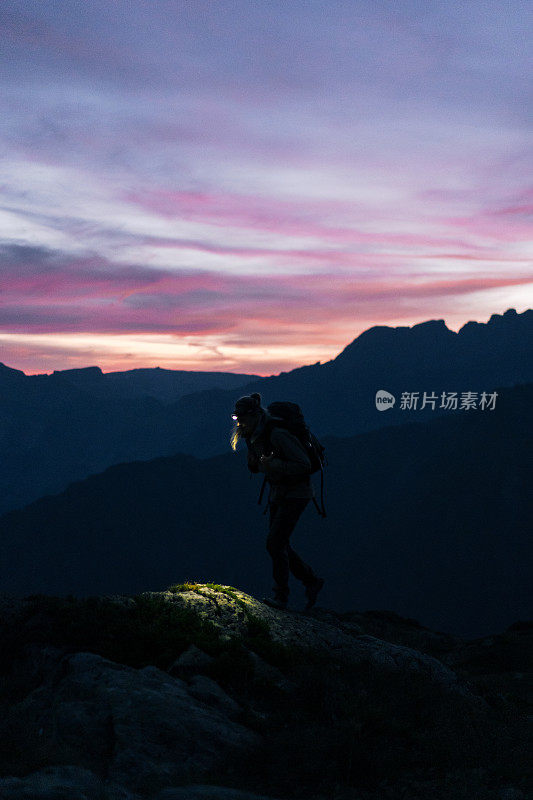 日出时，女徒步旅行者穿过山脊