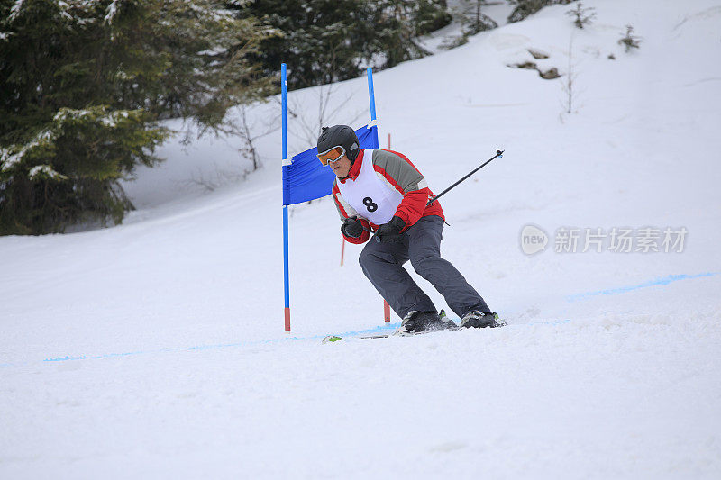 业余冬季运动高山滑雪大回转比赛。老年男子在滑雪场滑雪。高山雪景