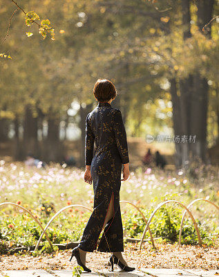 秋天走在树林里的中国妇女穿着传统的中国服装