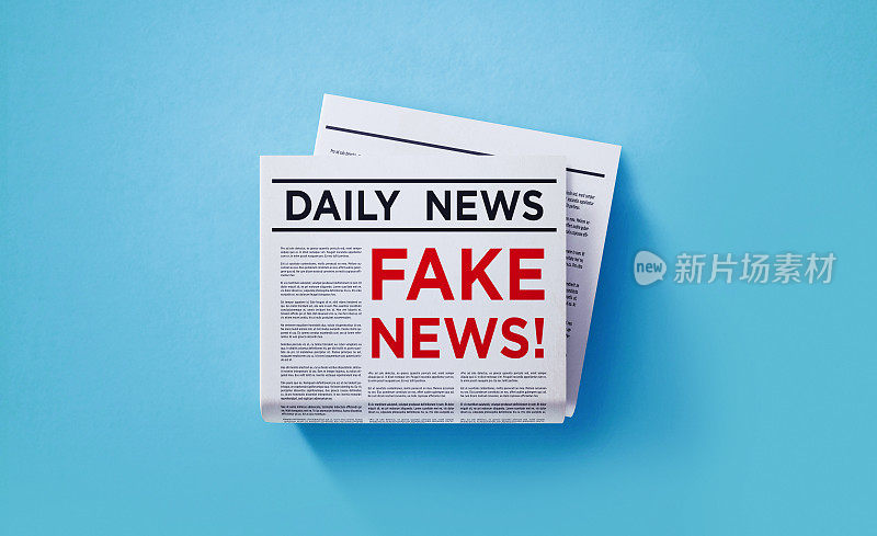假新闻概念-报纸与假新闻标题坐在报纸堆在蓝色背景