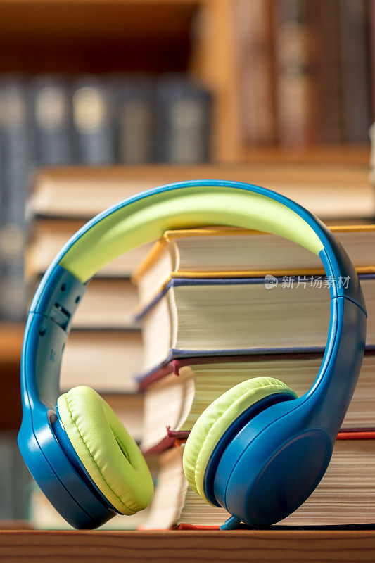 有声书概念-耳机与书堆在图书馆