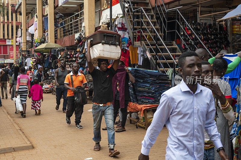 乌干达坎帕拉的街道上，一名男子头上顶着行李箱。