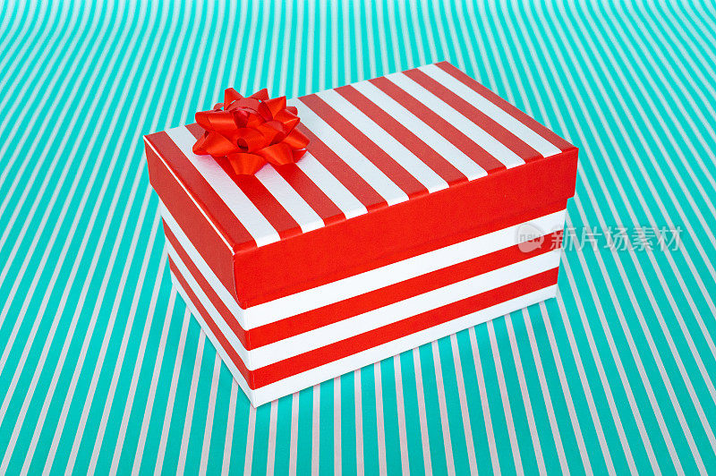 红白条纹礼盒与一个蝴蝶结上绿松石条纹背景股票照片