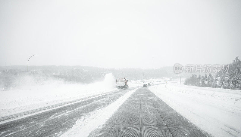 冬季公路和扫雪车在暴风雪期间