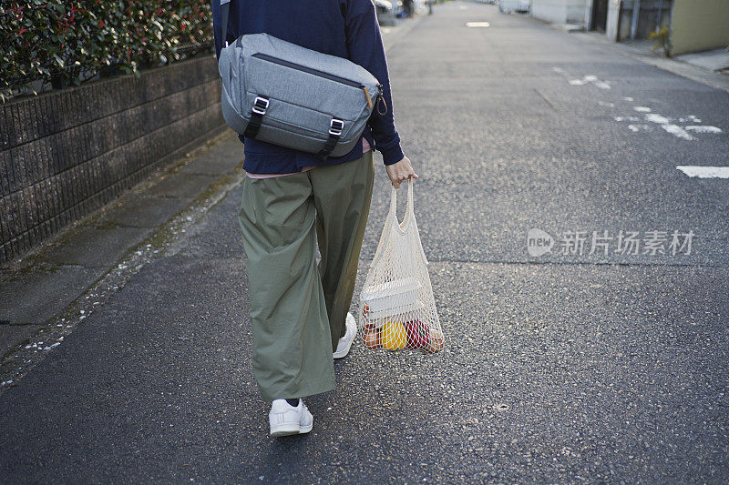 一名日本妇女在京都街头使用可重复使用的棉网袋