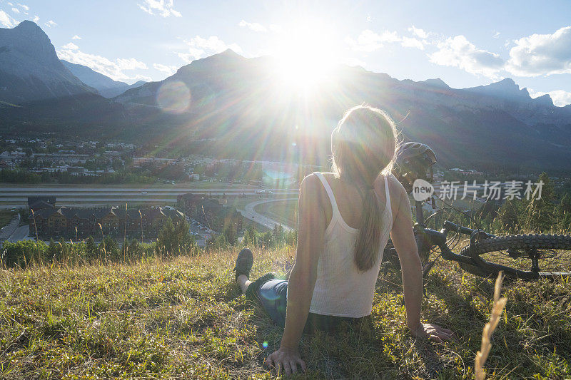 画像的年轻女子山地车旁边的山道