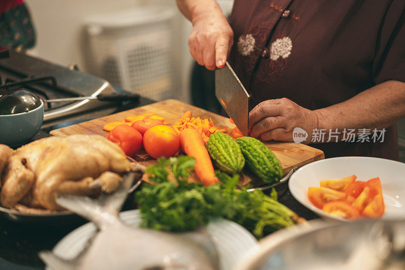 特写的亚洲妇女切胡萝卜和准备一顿大餐