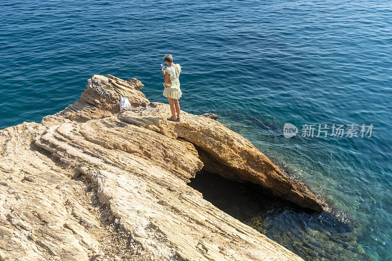 在海里的岩石上钻孔。女人在海里的洞里游泳。