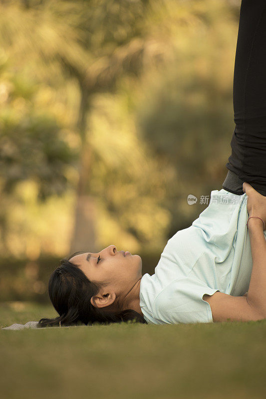少女做瑜伽和锻炼在公园股票照片