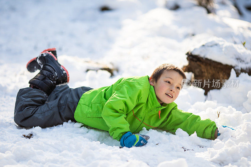 小男孩躺在雪地里