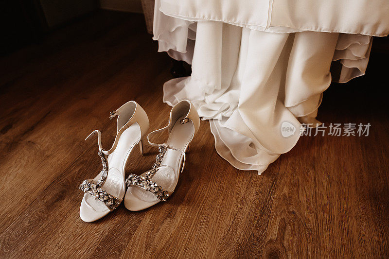 美丽的白色婚纱鞋与水钻和婚纱背后