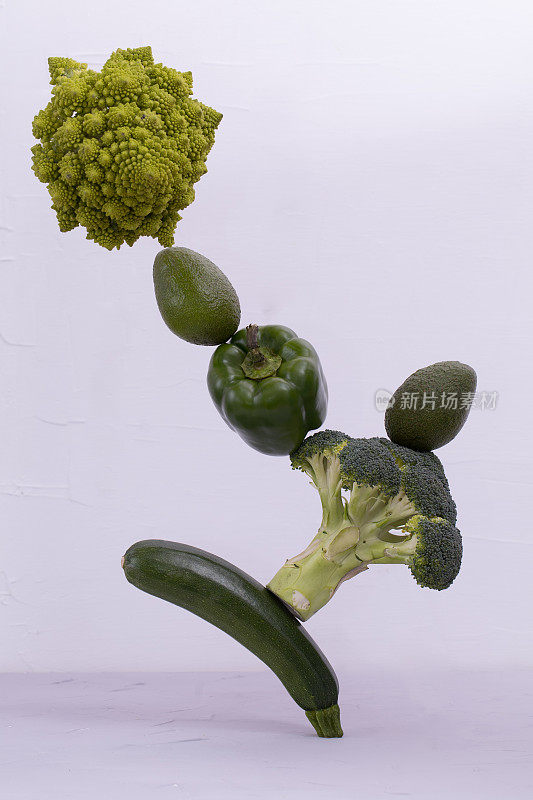 桌上放着新鲜的绿色蔬菜。西葫芦，辣椒，鳄梨，罗马花椰菜，漂浮的食物平衡概念，悬浮