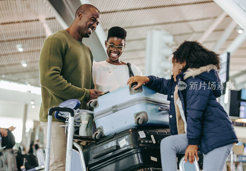 一个非洲家庭带着行李在机场等候