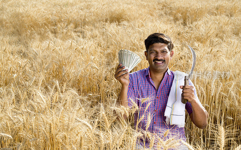 农民在农田里持有印度卢比钞票